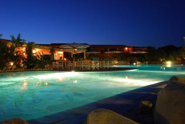 Noční pohled na bazén Hotelu Le Sabine s barem, Badesi, Sardinie