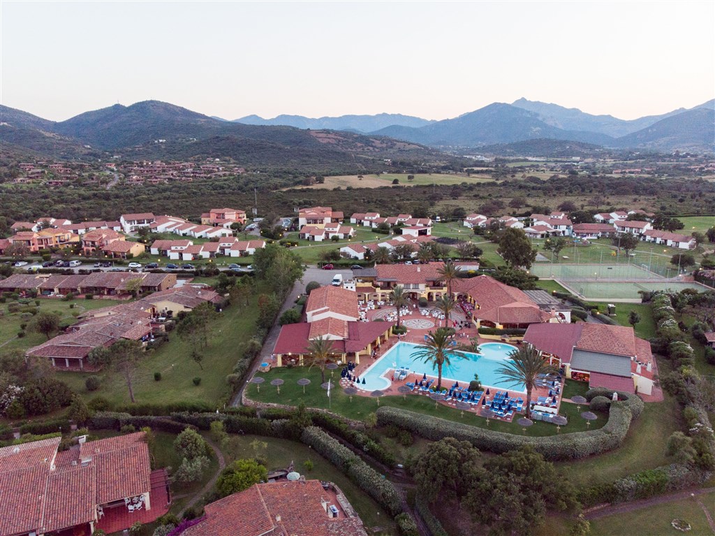 Letecký pohled na panorama hotelu s horami v pozadí, San Teodoro, Sardinie, Itálie