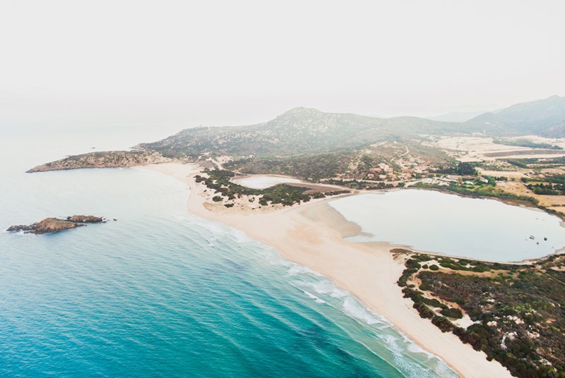 Letecký pohled na pláž a hotel,  Chia, Sardinie, Itálie