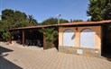 Residence Palm Village - Pohled ze zahrady na venkovní posezení pod pergolou, Villasimius, Sardinie